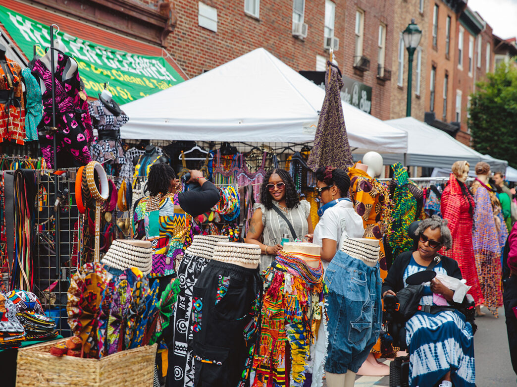 Visitors browse colorful African-inspired clothing, jeweley and accessories at vendor stalls during the Odunde Festival.