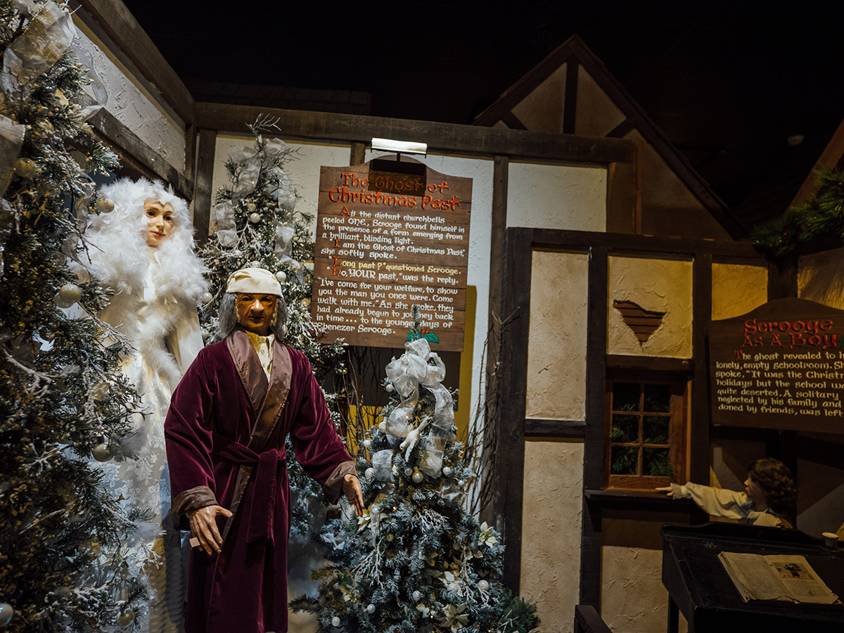 Animatronic figures from Dickens Village holiday display gaze at the viewer