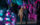 A couple strolls hand-in-hand through a tunnel of pink, blue and green holiday lights.