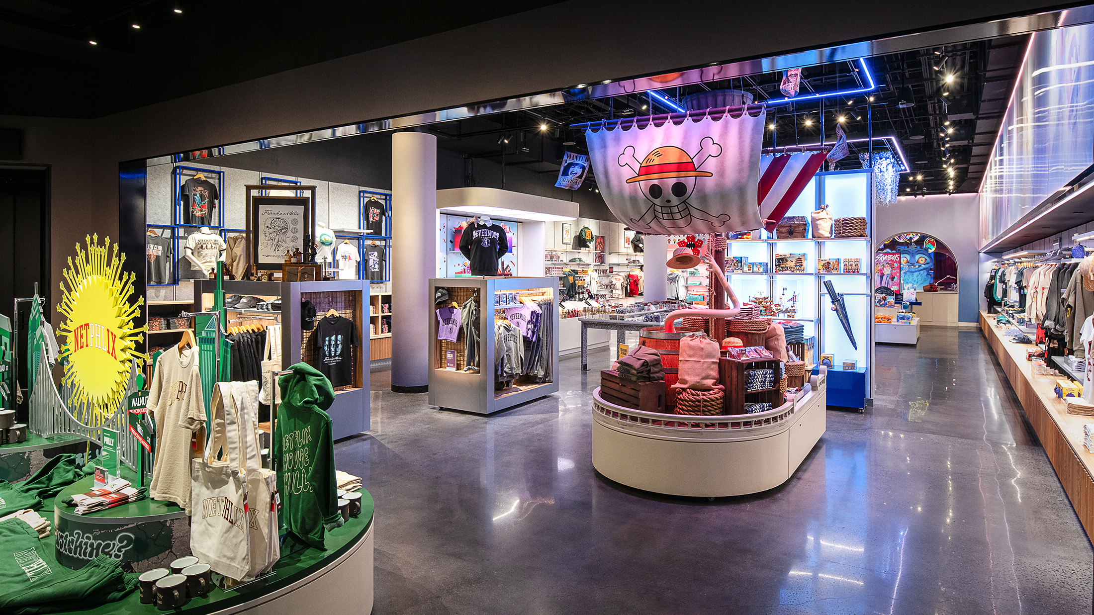 Inside a merchandise shop with displays overflowing with themed apparel, accessories and collectables beneath vibrant lighting and playful show-inspired decor.