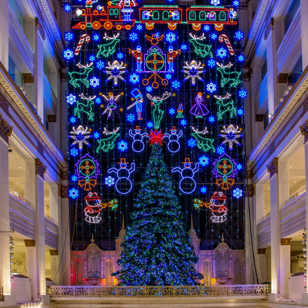 A towering Christmas tree and dazzling wall of holiday lights fill a large atrium in the Wanamaker building in Philadelphia.