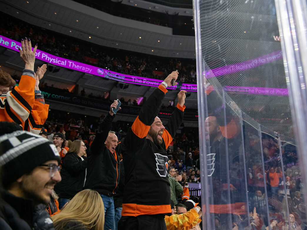 Flyers fans at Xfinity Mobile Arena smile and cheer.