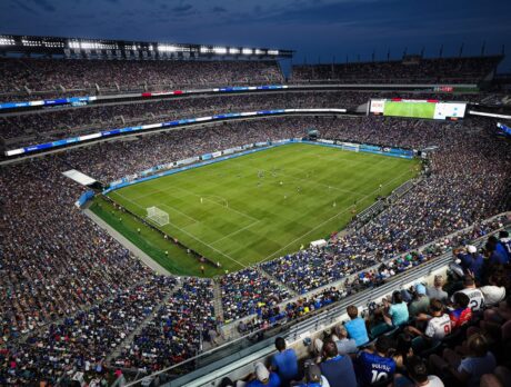 Group of fans watching soccer players at night at Lincoln Financial Field