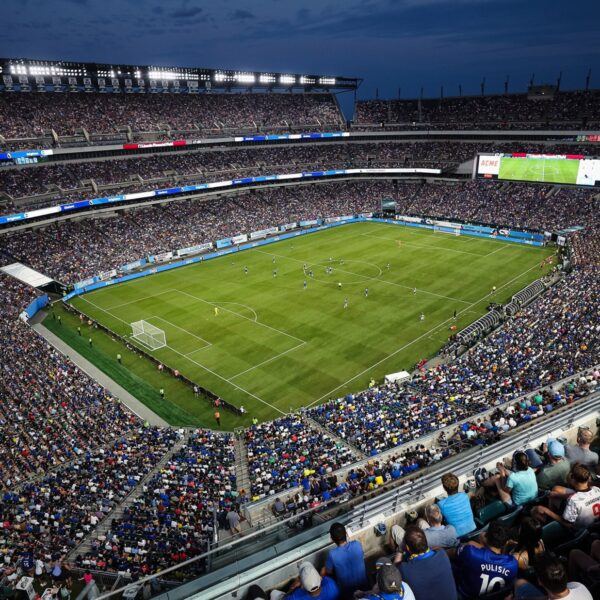 Group of fans watching soccer players at night at Lincoln Financial Field