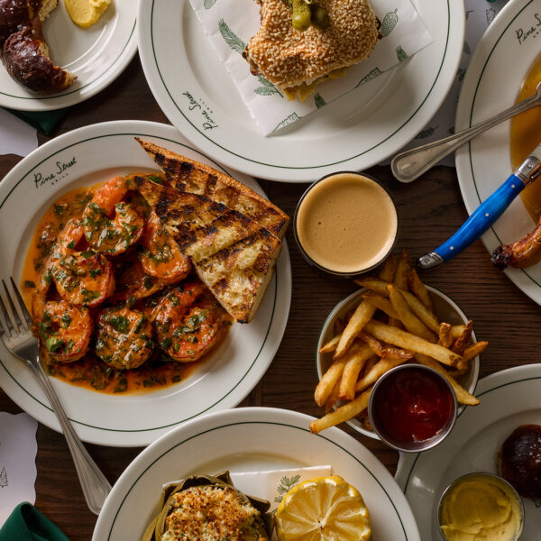 Une vue aérienne montre un éventail de plats de restaurant, dont du poulet rôti, des sandwichs, des crevettes en sauce, des frites et bien d'autres choses encore.