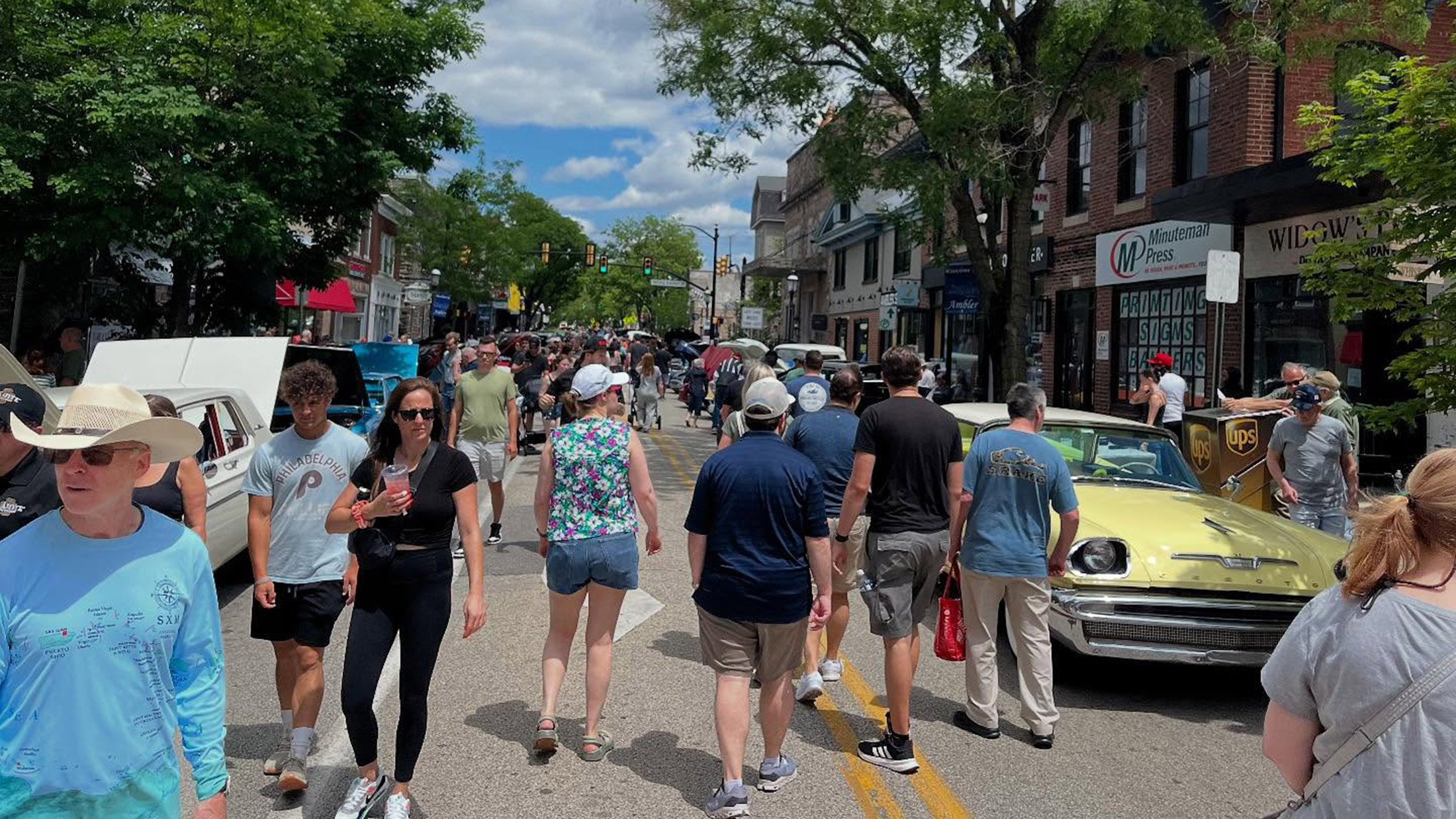 Une foule de gens se promène dans Main Street, à Ambler, en admirant les voitures anciennes.