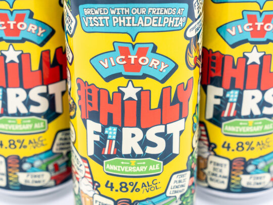 Gros plan sur une canette jaune vif de la bière Anniversary Ale "Philly First" de Victory Brewing, dont l'étiquette est ornée d'illustrations ludiques.