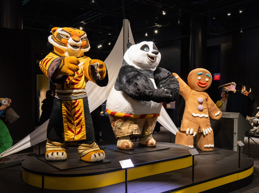 De grands costumes de personnages, dont un tigre, un panda et un pain d'épices, sont exposés à l'intérieur de la galerie d'exposition d'Universal Theme Parks.