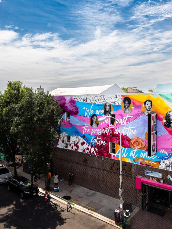 A colorful mural depicting the history of trans women sits above Philly Aids Thrift in Queen Village