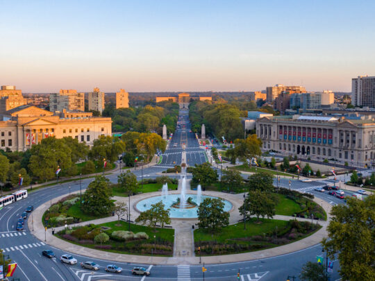 An aerial view of the Benjamin Franklin Parkway overlooking the fountain at Logan Square, the Barnes Foundation, Parkway Central Library and the Philadelphia Museum of Art.
