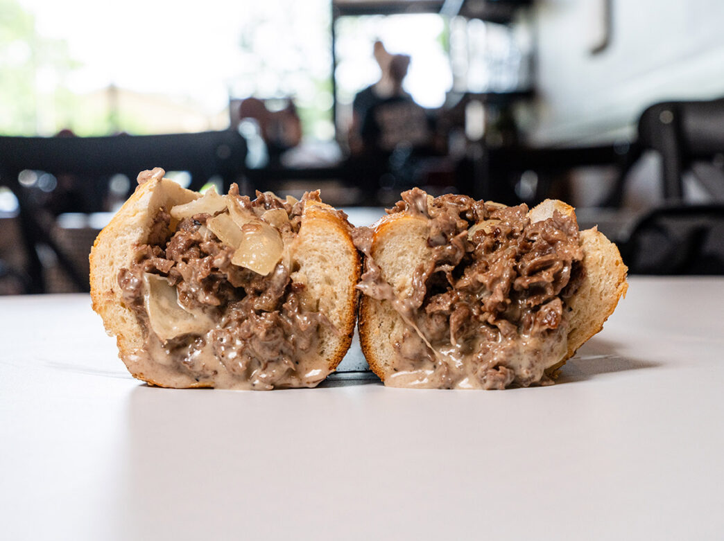 Um bife de queijo recheado e pegajoso fica em uma mesa no Cafe Carmela.