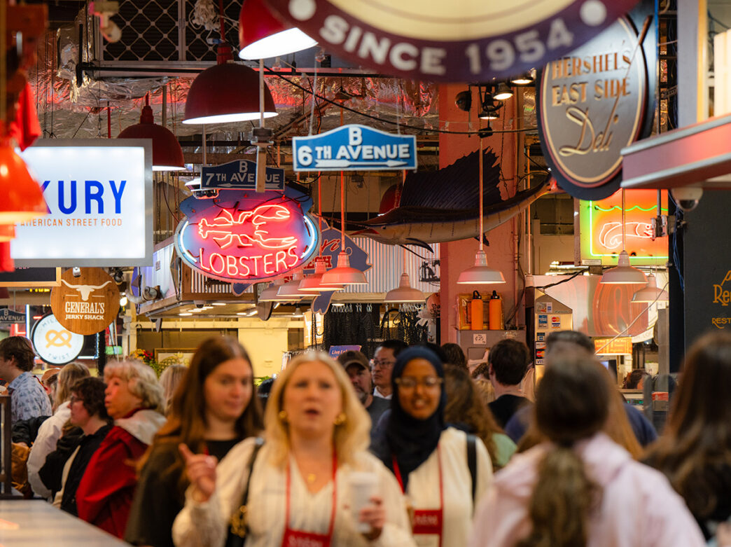 Los compradores llenan los pasillos de Reading Terminal Market bajo letreros de neón colgantes y carteles de los vendedores, entre los que destaca un llamativo letrero que dice “Langostas”.