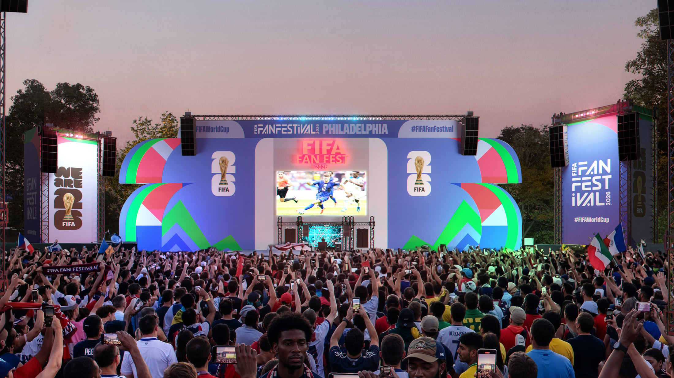 Una gran multitud se congregó frente a un colorido escenario en el Fan Festival de la Copa Mundial de la FIFA 2026 en Filadelfia, donde los aficionados sostenían sus teléfonos y banderas mientras se retransmitía un partido de fútbol en una pantalla gigante situada en el centro.