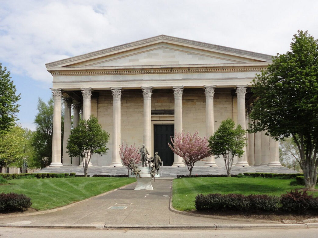 Trees, including blossoming cherry trees, outside of the Greek Revival-style Founders Hall Museum at Girard College