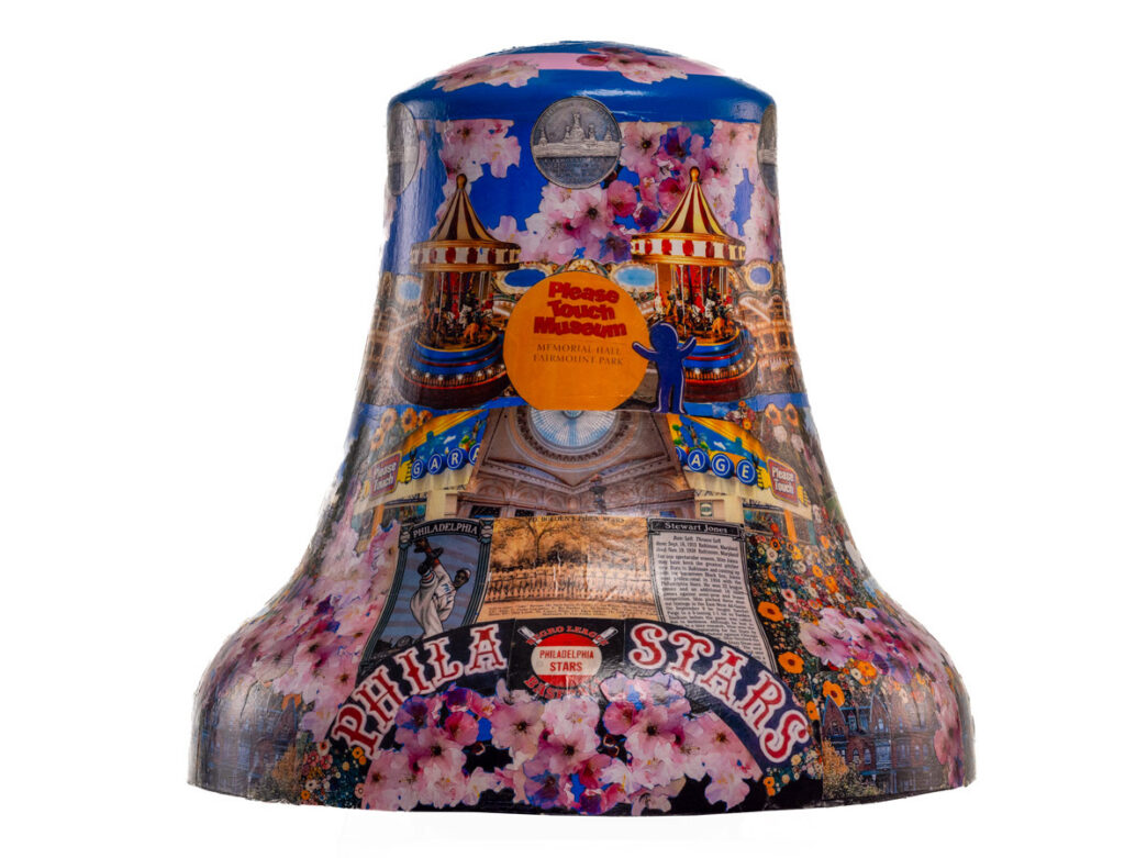Bell sculpture titled “Fun Facts and Historical Treasures of Fairmount Park” from Philadelphia250’s Bells Across PA, featuring a collage of imagery from Parkside. The design includes cherry blossoms, carousel scenes, and historic architecture, along with references to the Please Touch Museum and Memorial Hall. Text and graphics, including “Phila Stars,” are layered throughout, creating a vibrant tribute to the park’s history and attractions.