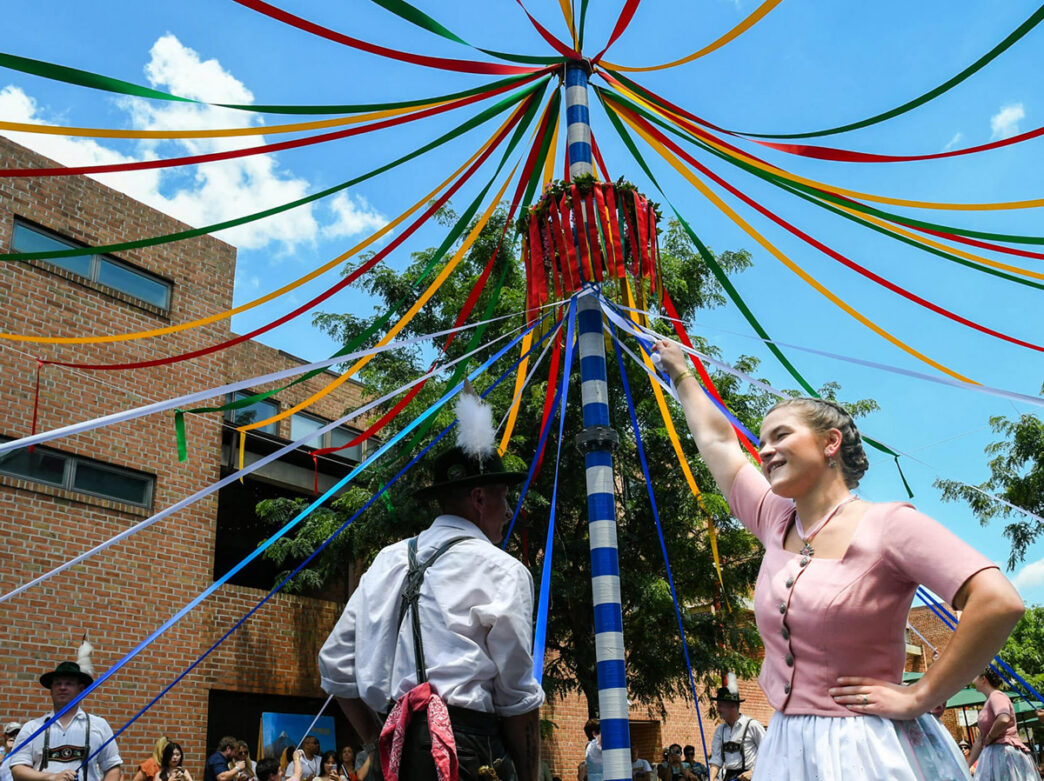 People dancing around the May pole on South Street during Maifest at Brauhaus Schmitz.