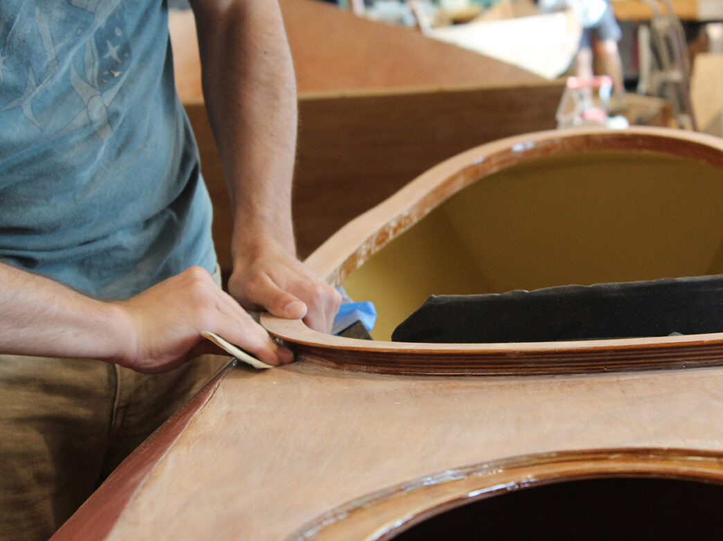 A man sanding a boat during a talk at the Independence Seaport Museum