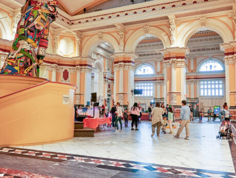 A crowd of visitors walk on a marble floor inside the Please Touch Museum.