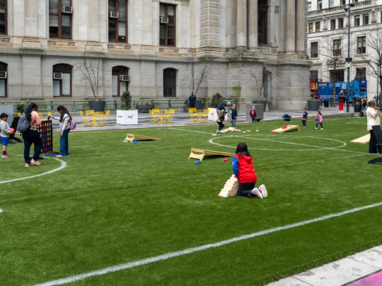 Children play games on a grass soccer field set up outside of Philadelphia's City Hall.
