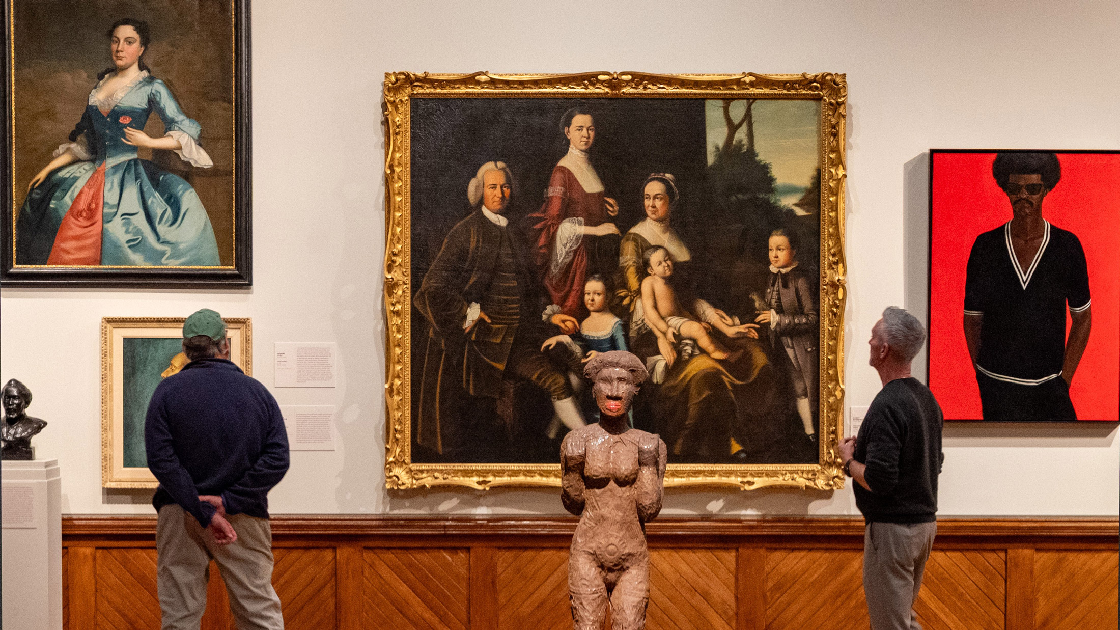 Visitors view a large historic family portrait alongside contemporary artwork and a central sculpture in the “A Nation of Artists” exhibit at the Pennsylvania Academy of the Fine Arts in Philadelphia.