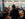 A waitress at Amma's South Indian Cuisine in Philadelphia holds a plate of samosas while speaking to a group dining at a table.
