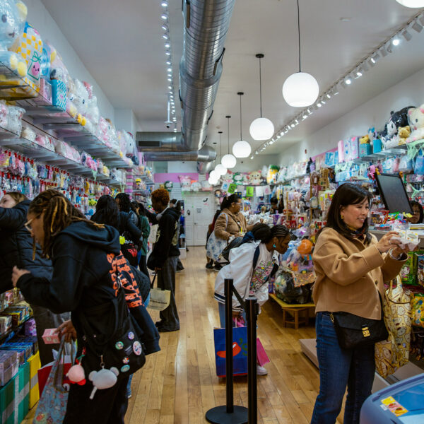 Un grupo de compradores examina detenidamente los coloridos artículos, entre los que se incluyen peluches y naipes, en Asia Crafts