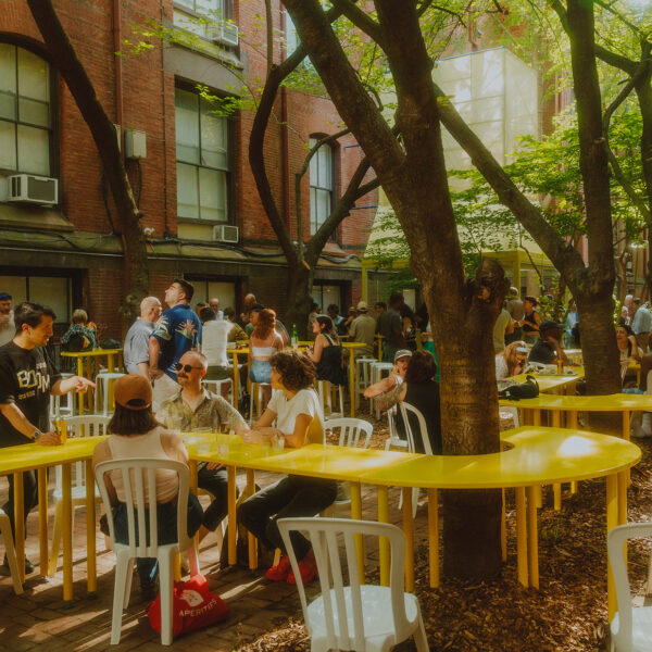 Des gens s'assoient autour de troncs d'arbres tandis qu'une table jaune s'enroule autour d'un arbre au Frankie's Summer Club à Philadelphie.