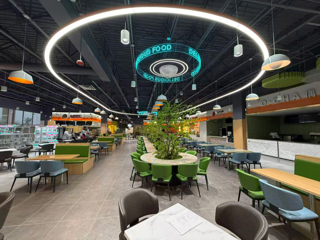 Een helder verlicht foodcourt met tafels en stoelen bij Hung Vuong Supermarkt.