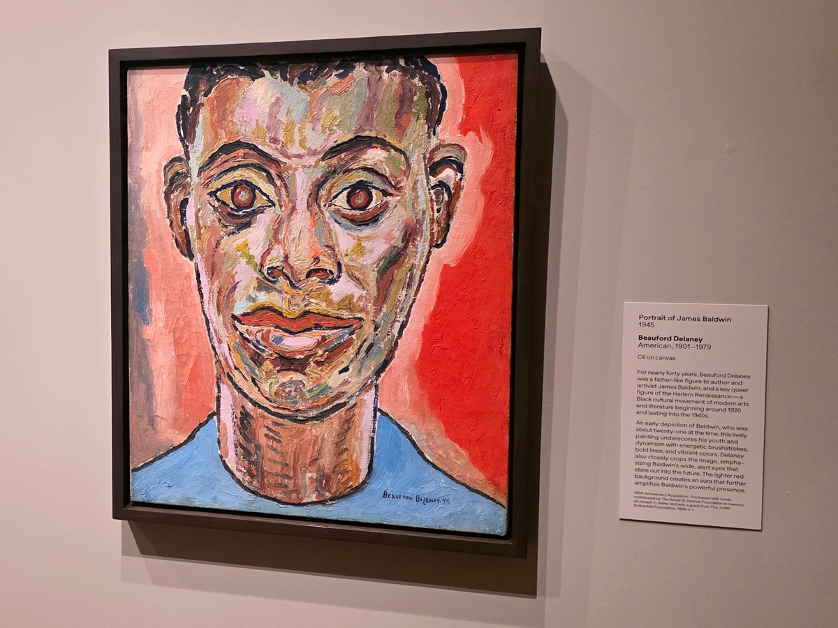 Expressive painted portrait of James Baldwin by Beauford Delaney, featuring bold brushstrokes and vivid colors, displayed with wall text in the “A Nation of Artists” exhibit in Philadelphia.