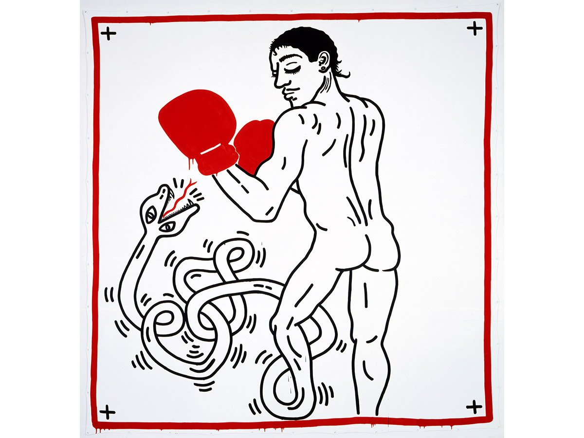 A large-scale painting by Keith Haring depicting a nude male figure wearing bold red boxing gloves punching a coiling serpent, rendered in black line art on white within a red border, from the Philadelphia Museum of Art's collection.