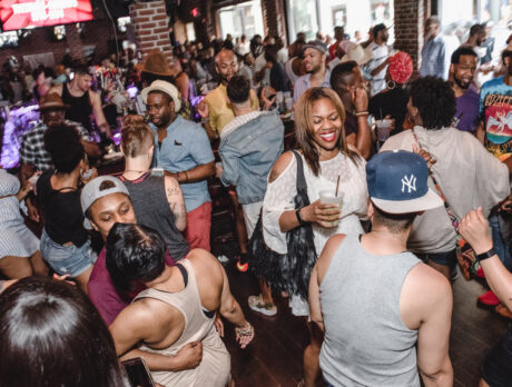 People dance and talk at a party in a bar as part of Philly Black Pride.