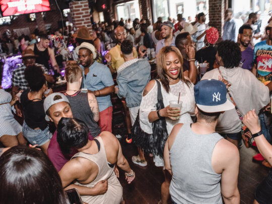 La gente baila y charla en una fiesta celebrada en un bar como parte del Philly Black Pride.