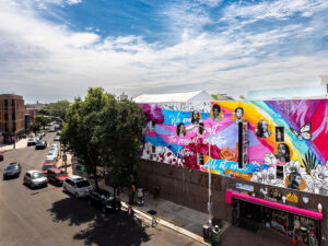 A colorful mural depicting the history of trans women sits above Philly Aids Thrift in Queen Village.