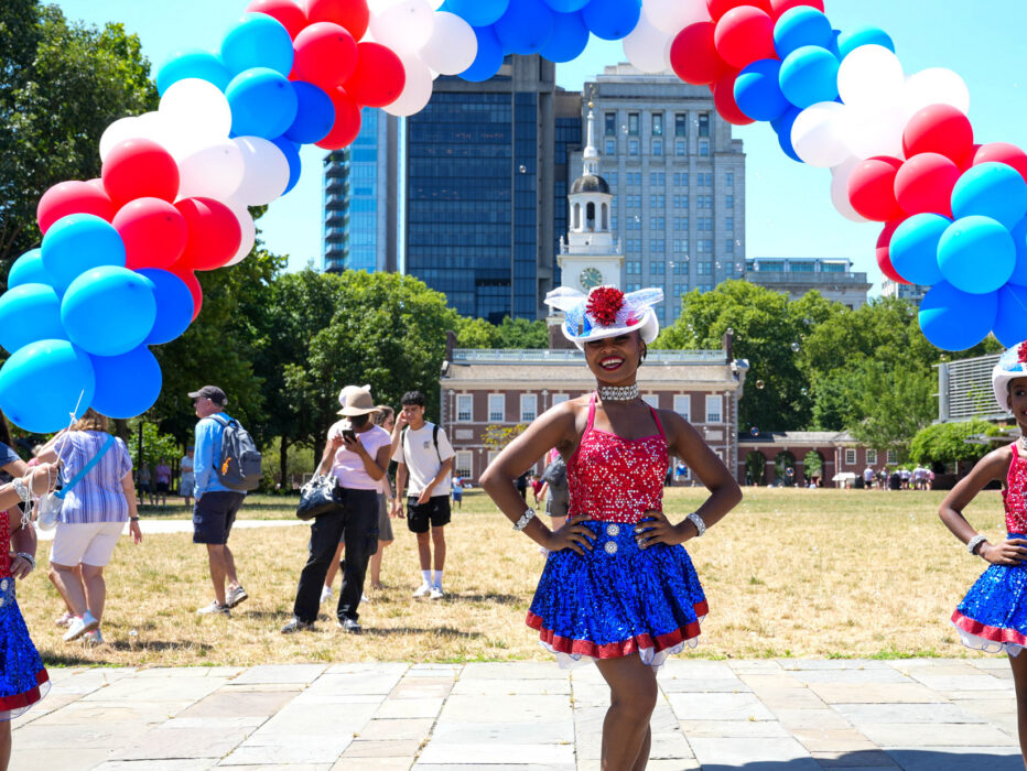 Three people in patriotic outfits in front of Independence Hall during the Red White & Blue To Do.