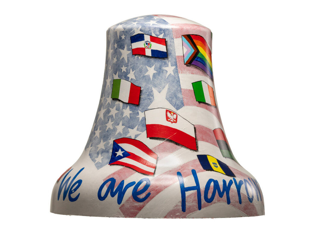 Colorfully painted bell titled “We Are Harrowgate” featuring an American flag motif and a collage of international flags and a Pride flag, representing the diversity of Philadelphia’s Harrowgate neighborhood as part of Philadelphia250’s Bells Across PA.