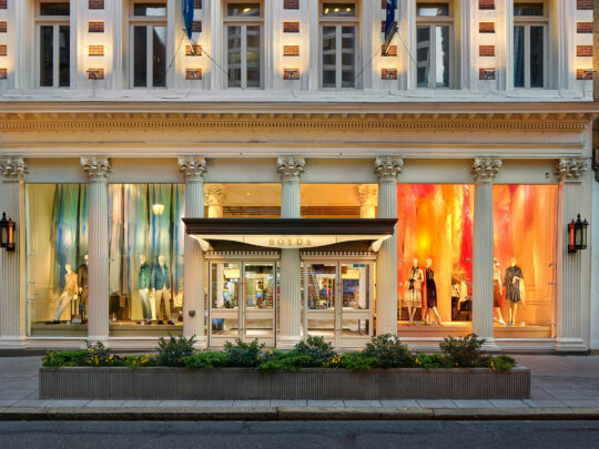 De buitenkant van een helder verlichte luxe winkel, Boyds Philadelphia, aan de overkant van een rustige straat.