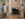 Two historical reenactors in 18th-century colonial clothing converse inside a historic Philadelphia room with a fireplace, checkered floor, and period furnishings.