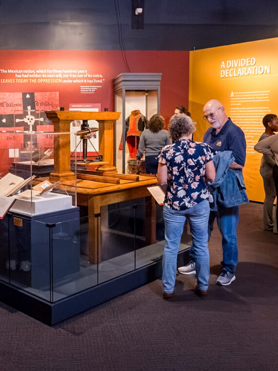 Visitors explore 'The Declaration's Journey' exhibition at the Museum of the American Revolution, examining displays about Independence Movements and A Divided Declaration with interactive exhibits and historical artifacts.