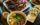 A table full of Asian cuisine, including a plate of roasted duck and a bowl of wonton noodle soup at Sang Kee Peking Duck House