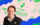 Visit Philadelphia's resident FIFA World Cup 26 expert Andrew Zwarych poses against a graphic background featuring Philadelphia-themed illustrations, including a hoagie, sports gloves, a soccer ball, and raised champagne glasses. Bold blue and green geometric patterns frame the image, creating a colorful, modern portrait.