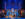 Performers in dazzling blue costumes sing and dance beneath an Art Deco-inspired set during a production of The Great Gatsby.