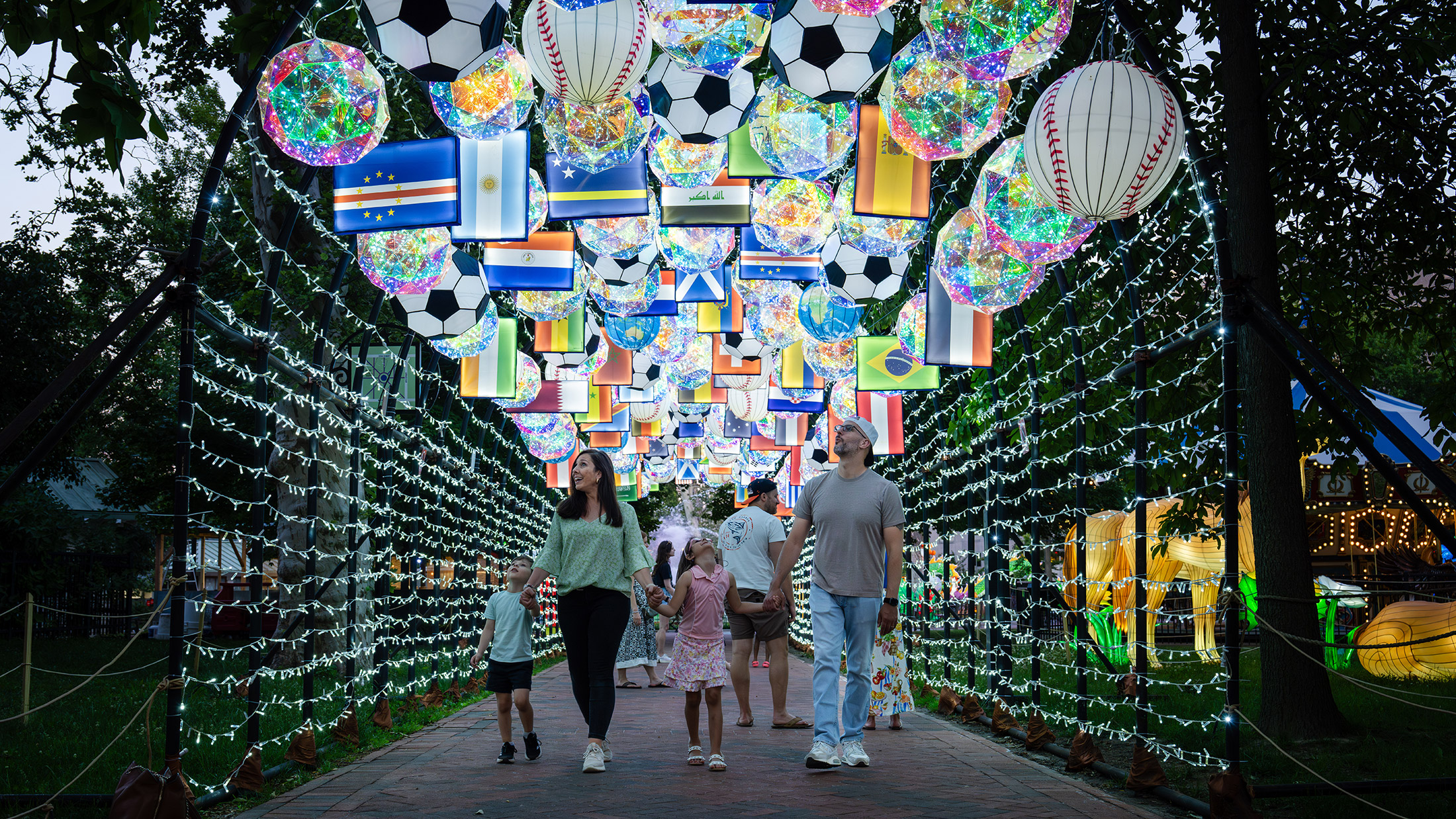 Uma família caminha sob o Túnel dos Campeões, uma instalação especial criada para comemorar a 250ª edição do Festival das Lanternas da China de 2026.