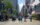 Voetgangers steken een druk kruispunt in Center City over langs Market Street, omringd door hoge gebouwen, bussen en spandoeken met motieven uit Philadelphia. In de verte, aan het einde van de straat, doemt Philadelphia City Hall op, omlijst door bomen en winkelpuien in het centrum.