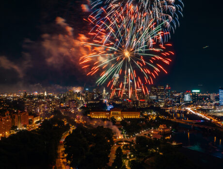 Fireworks burst above the Philadelphia skyline at night, illuminating the Benjamin Franklin Parkway, the Philadelphia Museum of Art and Center City skyscrapers during a Fourth of July celebration.