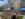 Dancers in colorful traditional attire perform on a grassy plaza during a b[l]ok party at Bok in South Philadelphia. Spectators gather around the outdoor performance space, while vendors, live music, and activities fill the street in front of the historic Bok building on a sunny day.