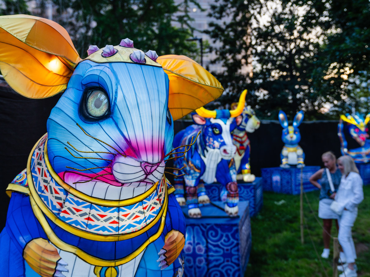Uma escultura colorida em forma de lanterna representando um rato azul destaca-se entre outras lanternas com animais do zodíaco no Festival Chinês das Lanternas.