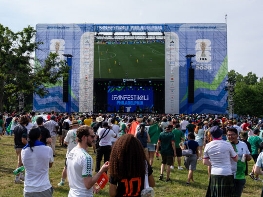 A crowd watches a giant TV screen showing World Cup soccer at FIFA Fan Fest in Philadelphia