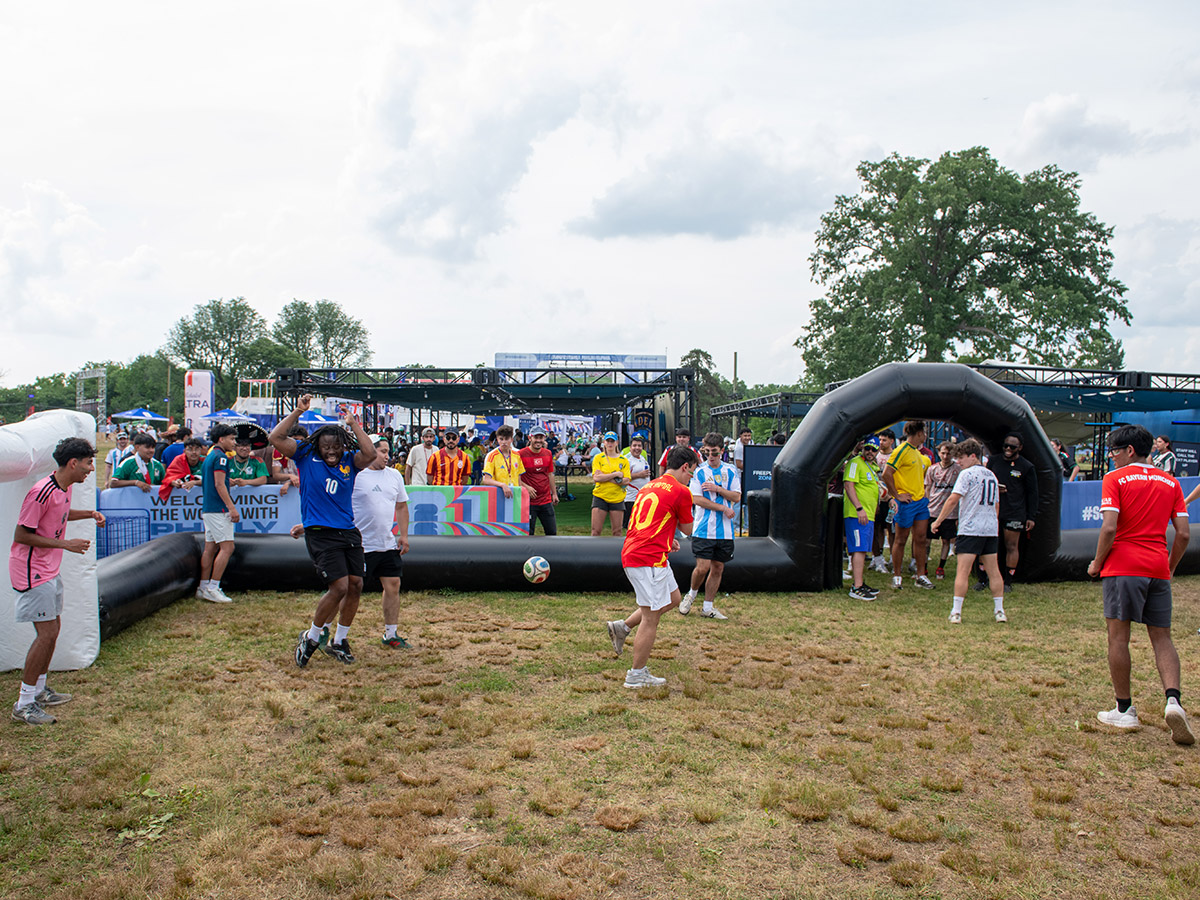 Un grupo de personas jugando al fútbol en una cancha improvisada durante el Festival de los Fanáticos de la FIFA