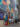 **Alt text:** A group of pedestrians walks along a Center City sidewalk beside a vibrant mural celebrating Philadelphia landmarks, culture and history. The colorful artwork stretches down the block near a bus shelter and modern office buildings.