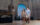 À l'intérieur du Penn Museum de Philadelphie, un couple se promène dans une galerie spacieuse tout en admirant des objets anciens. Une sculpture massive en pierre ressemblant à un gardien mythologique domine le premier plan, tandis que d'autres statues historiques et détails architecturaux sont visibles dans l'intérieur grandiose du musée.